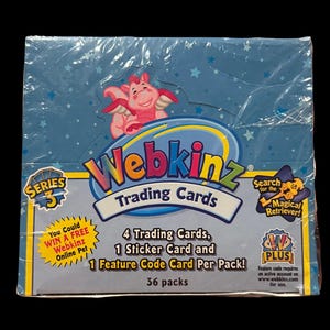 May include: A sealed box of Webkinz Series 3 trading cards. The box is blue with a star pattern and features a pink dragon graphic. Text includes "Trading Cards", "36 packs", and "Magical Retriever!"