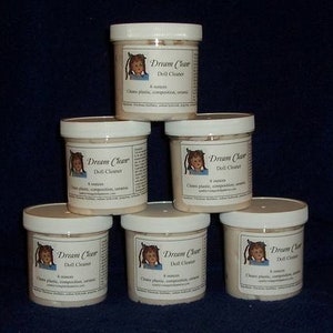 May include: Six 8-ounce jars of doll cleaner labeled "Dream Clear Doll Cleaner". The jars are white with a white lid and feature a cartoon girl on the label.