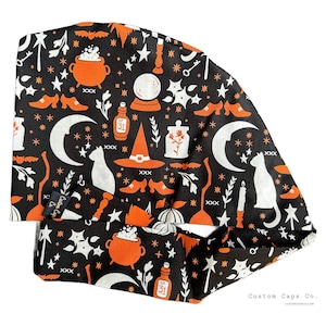 May include: A black and orange fabric scrub hat with a Halloween theme. The hat features a repeating pattern of witches hats, cauldrons, cats, moons, stars, and potion bottles. The text "No. 31" appears on the hat.