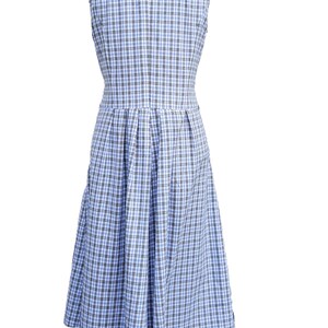 May include: A sleeveless blue and white plaid dress with a pleated skirt.