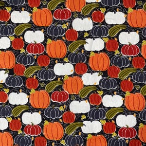 May include: A repeating pattern of pumpkins and gourds in various colors, including orange, red, white, and navy blue, on a black background. The pumpkins have green stems and are interspersed with green gourds. The design has a hand-drawn, sketched aesthetic.