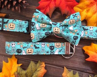 May include: A teal blue bow tie and matching dog collar with a Halloween theme. The fabric features a pattern of ghosts, candy corn, bats, and skulls on a teal blue background. The text "Boo!" is printed on the fabric.