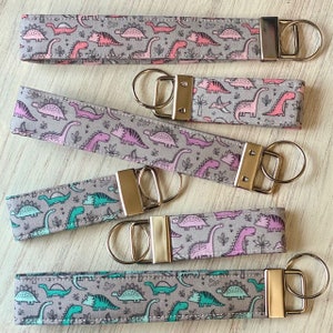 keychain , key fob, dinosaur, dino, t-rex, stegosaurus, triceratops, pterodactyl, brontosaurus, pink, purple, green, turquoise, pre-historic