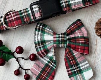 May include: A red, green, and white plaid dog collar and matching bow tie. The collar has a black plastic buckle.