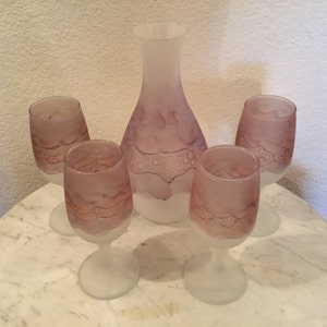 May include: Set of five frosted glass decanter and wine glasses with a purple and brown swirl design.