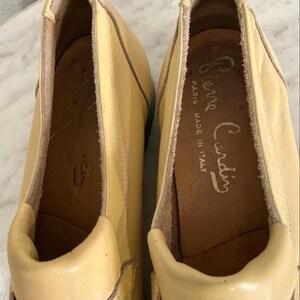 Puede incluir: Un par de mocasines Pierre Cardin de color amarillo claro. Los zapatos son de cuero y tienen una puntera redondeada y un tac&oacute;n bajo. El interior del zapato est&aacute; estampado con el logotipo de Pierre Cardin y "Paris Made in Italy".