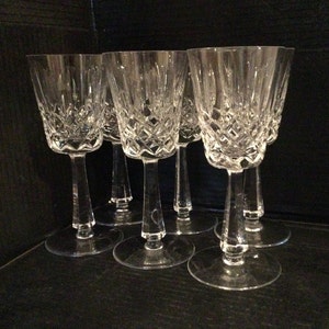 May include: Set of six clear crystal wine glasses with a diamond pattern. The glasses have a tall, slender stem and a round bowl.