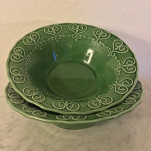 Może przedstawiać: Zestaw dwóch zielonych ceramicznych misek z białym wzorem dekoracyjnym. Miski są włożone jedna w drugą.