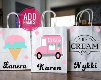 May include: Three white paper gift bags with handles. The bags have different ice cream themed designs. One bag has an ice cream cone, one has an ice cream truck, and one has a sign that says "ICE CREAM". The bags are labeled with the names "Lanera", "Karen", and "Nykki".