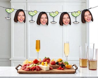 May include: A festive party scene with a garland of margarita glasses and winking faces. A wooden serving board displays a variety of appetizers, accompanied by champagne flutes and glasses of bubbly drinks. The setting is a bright, inviting space.