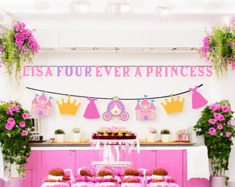 May include: A princess-themed party setup with pink and gold decorations. A banner reads "LISA FOUR EVER A PRINCESS". The scene includes a cake, cupcakes, and decorative cutouts of castles, crowns, dresses, and a carriage.