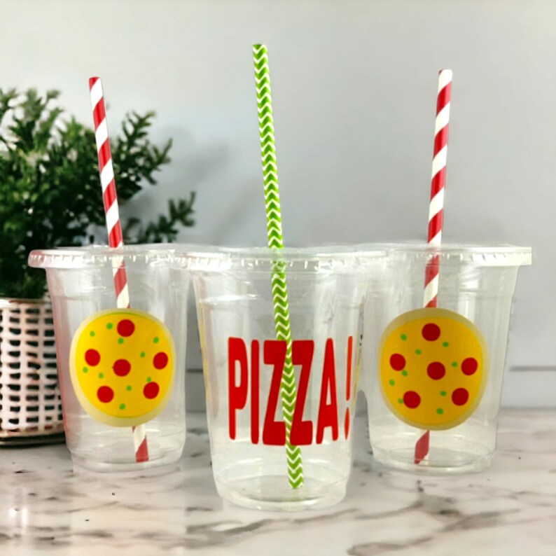 Puede incluir: Tres vasos de pl&aacute;stico transparente con pajitas de rayas rojas y blancas. Los vasos tienen dise&ntilde;os con tem&aacute;tica de pizza, uno con la palabra "&iexcl;PIZZA!" y dos con una rebanada de pizza de dibujos animados.