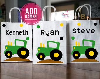 May include: Three white paper gift bags with green and yellow tractor designs and the names Kenneth, Ryan, and Steve printed on them.