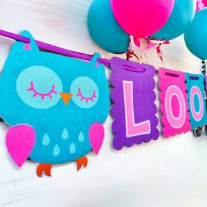 May include: A colorful banner with the word "LOOO" in pink and purple letters. The banner also features a blue owl with pink accents and orange feet.
