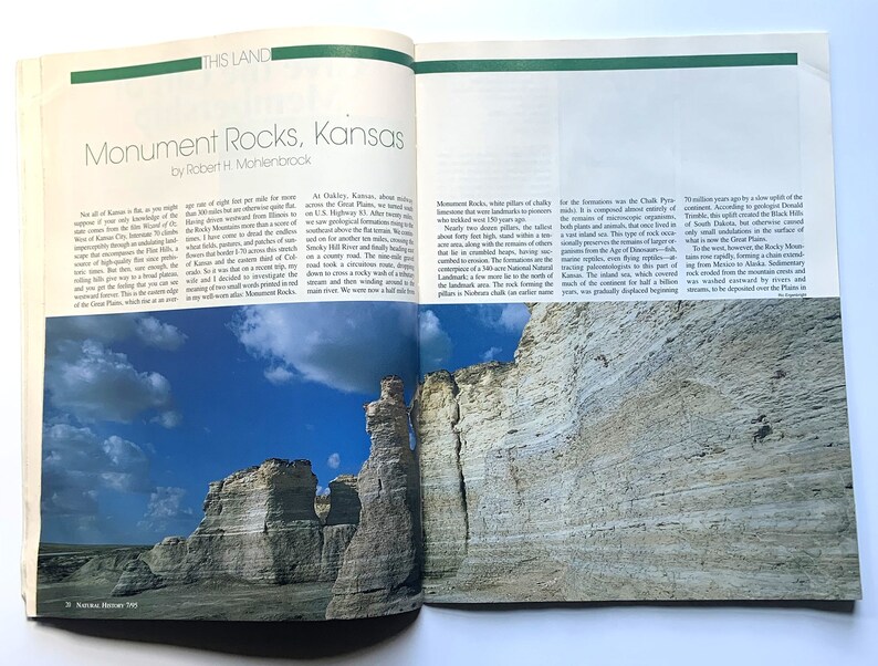 May include: Monument Rocks, Kansas, a natural landmark, features towering white chalk formations against a blue sky with fluffy clouds. The rocks are a unique geological formation, a remnant of the ancient inland sea.