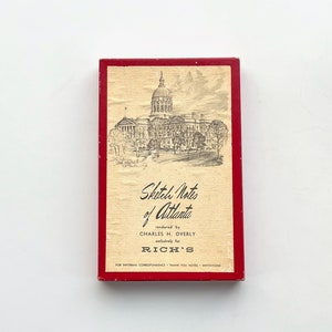May include: A red and cream box with a black and white illustration of the Georgia State Capitol building. The box is labeled "Sketch Notes of Atlanta" and "rendered by CHARLES H. OVERLY exclusively for RICH'S". The box is for informal correspondence, thank you notes, and invitations.