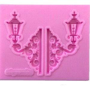 May include: Pink silicone mold for baking or crafting, featuring two detailed lamppost designs with ornate scrollwork.