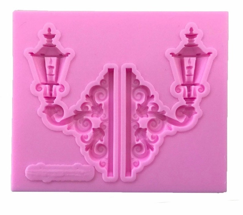 May include: Pink silicone mold for baking or crafting, featuring two detailed lamppost designs with ornate scrollwork.