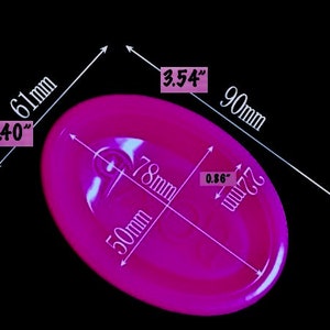 May include: A bright pink ear mold with measurements in inches and millimeters. The mold is 3.54 inches wide, 2.40 inches long, and 0.86 inches thick.