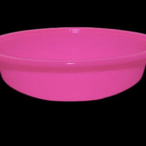 May include: A bright pink plastic bowl. The bowl is round and has a smooth surface.