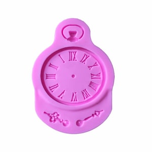 May include: Pink silicone mold shaped like a pocket watch with Roman numeral clock face and a keyhole on top. The mold also includes two smaller molds for decorative elements.