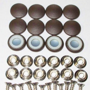 May include: A set of brown leather upholstery buttons with white plastic inserts, silver metal snaps, and silver screws. The buttons are used for furniture upholstery.