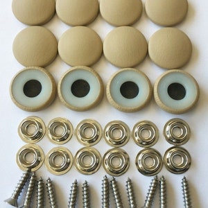 May include: A set of 12 beige round furniture pads with a white center, 12 silver metal washers, and 12 silver screws. The pads are designed to protect floors from scratches.