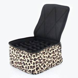 May include: A leopard print zippered travel case with a black padded interior and multiple compartments for storing small items.