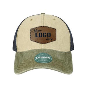 May include: A baseball cap with a beige front panel, dark blue mesh back, and an olive green brim. A brown faux leather patch is centered on the front with the text Your LOGO here. A green sticker on the brim reads LEGACY DASHBOARD.