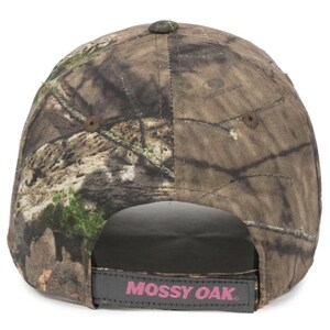 May include: A camouflage baseball cap with a curved peak. The cap has a brown, green, and tan pattern. The adjustable strap at the back has the words "Mossy Oak" in pink lettering.