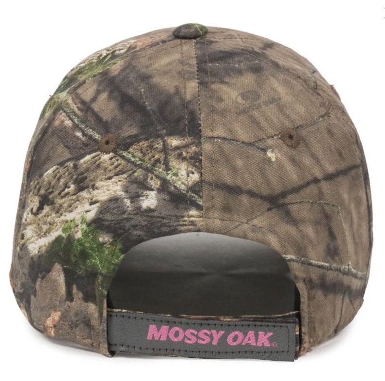 May include: A camouflage baseball cap with a curved peak. The cap has a brown, green, and tan pattern. The adjustable strap at the back has the words "Mossy Oak" in pink lettering.