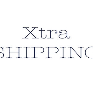以下が含まれることがあります： 白の背景に、濃い青色のエレガントなフォントで「Xtra SHIPPING」という文字が書かれています。「Xtra」という単語は小さいフォントサイズで、「SHIPPING」という単語の上にあります。