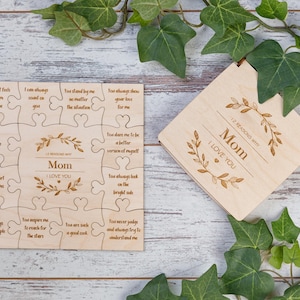 May include: Wooden puzzle with 12 pieces featuring a floral design and the words "I love you Mom". The puzzle is in a wooden box with the same floral design and the words "I love you Mom".