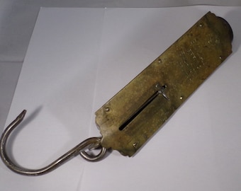 May include: Antique brass hanging scale with a hook and a needle pointer on a graduated scale. The scale is marked "The Improved Patent Hanging Scale, Made by The Fairbanks Co., New York."