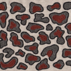 May include: A beige fabric with a repeating pattern of brown and gray embroidered spots. The spots are irregular in shape and size, resembling animal print.