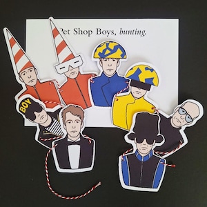 Puede incluir: Un conjunto de recortes de papel con ilustraciones de los Pet Shop Boys, unidos como una guirnalda. Las figuras visten diversos atuendos, incluyendo chaquetas naranjas con sombreros cónicos, un esmoquin y un sombrero de copa. El texto Pet Shop Boys, bunting. es visible.