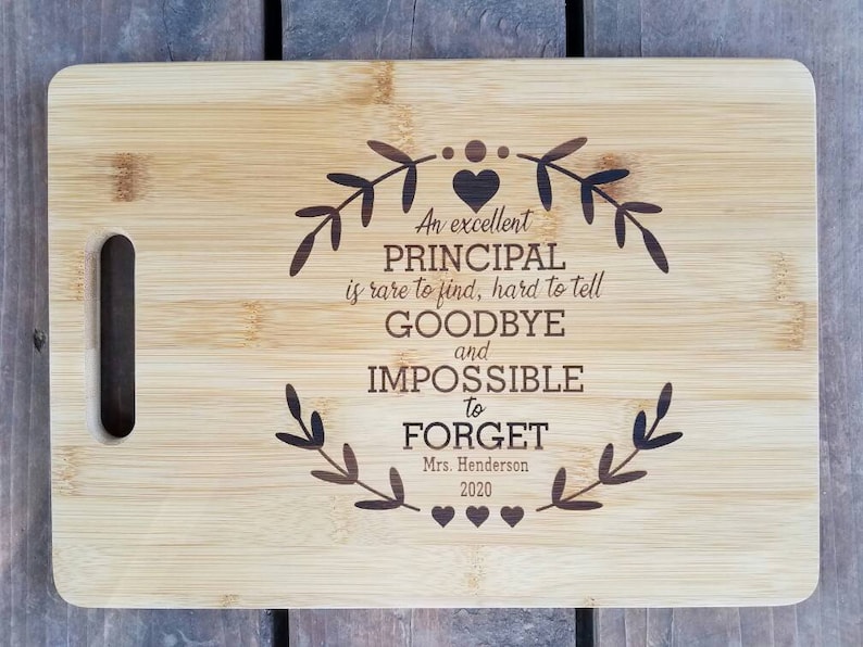 May include: A bamboo cutting board with a laser engraved message that reads "An excellent PRINCIPAL is rare to find, hard to tell GOODBYE and IMPOSSIBLE to FORGET. Mrs. Henderson 2020".