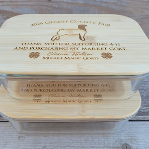 May include: Two-piece glass baking dish set with bamboo lids. The lids are engraved with text and a goat silhouette, including "2024 Genesee County Fair" and "Thank you for supporting 4-H".
