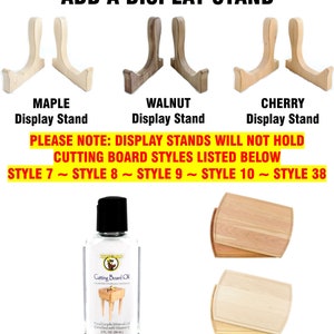 May include: Three wooden display stands in maple, walnut, and cherry wood. The stands are for displaying cutting boards. The text "PLEASE NOTE: DISPLAY STANDS WILL NOT HOLD CUTTING BOARD STYLES LISTED BELOW STYLE 7 ~ STYLE 8 ~ STYLE 9 ~ STYLE 10 ~ STYLE 38" is displayed below the stands. A bottle of cutting board oil is shown below the text. The bottle is labeled "Cutting Board Oil" and has a picture of a cutting board on it. The text "ADD A BOTTLE OF CUTTING BOARD OIL 2 FL. OZ." is displayed below the bottle.