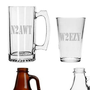 May include: Set of seven glass beverage containers with various sizes and shapes. The containers are etched with the text "N2AWT", "W2EZY", and "K2FA".