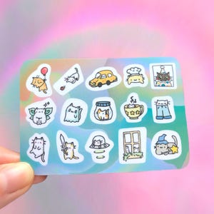 May include: A sheet of colorful stickers featuring various illustrations of cats in different poses and situations. The stickers are on a holographic background and include images of cats wearing hats, flying, riding in a car, and more.