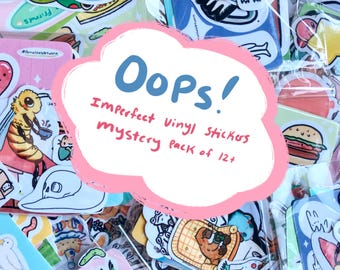 Puede incluir: Una colección de pegatinas de vinilo coloridas en una bolsa transparente. Las pegatinas presentan varias ilustraciones, incluyendo una abeja, una calavera y una hamburguesa. El texto en una nube rosa dice "Oops! Imperfect Vinyl Stickers mystery pack of 12+".