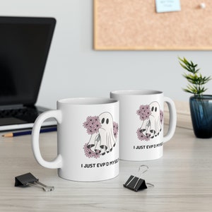 May include: Two white ceramic mugs featuring a ghost holding flowers and the text "I just EVP'd myself".