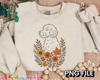 May include: Beige sweatshirt with a dog illustration surrounded by fall flowers and leaves. The graphic includes sunflowers, orange and yellow flowers, and autumn leaves. The text "PNG FILE 300 DPI" is also visible.