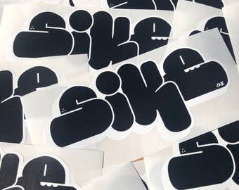 Op de afbeelding: Meerdere zwart-wit stickers met het woord "sike" geschreven in een cartoon lettertype. De stickers zijn op een witte achtergrond.