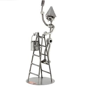 May include: A metal figurine of a person standing on a ladder, holding a paintbrush and a bucket. The figurine is made of various metal parts, including nuts, bolts, and washers. The ladder has five rungs and is attached to a round base.