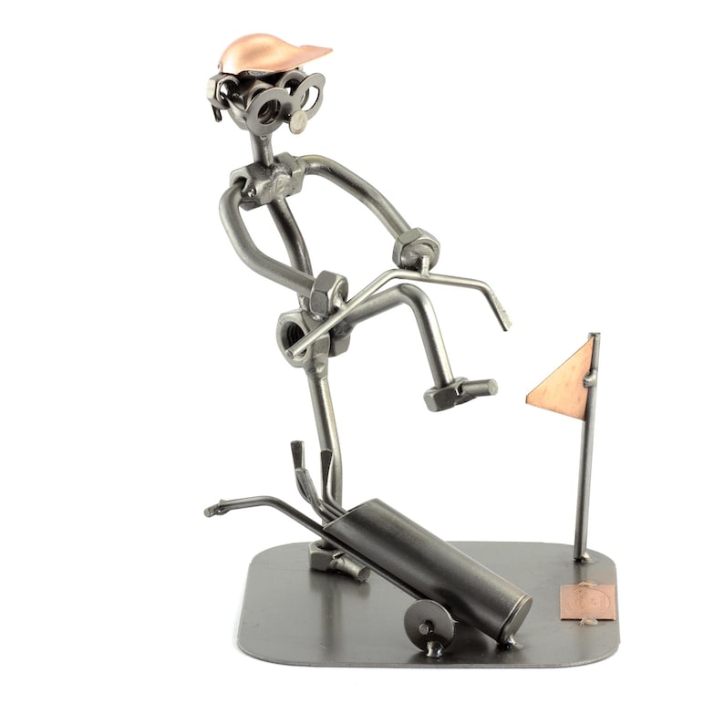 May include: A metal sculpture of a golfer swinging a club, with a golf bag and flag in the background. The sculpture is made of nuts, bolts, and other metal pieces.