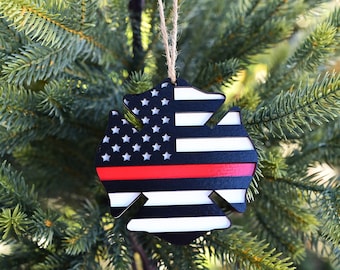 May include: A wooden Christmas ornament shaped like a firefighter's Maltese cross. The ornament is painted with the American flag and a thin red line across the center.