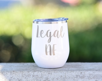 May include: White stainless steel wine tumbler with a silver inscription that reads "Legal AF".