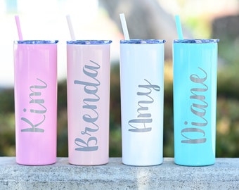 May include: Four personalized stainless steel tumblers with straws. The tumblers are pink, light pink, white, and light blue. The names Kim, Brenda, Amy, and Diane are printed on the tumblers.
